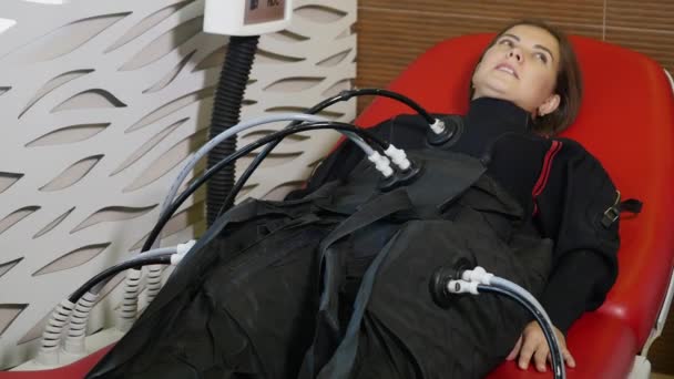 Kosmetický salon. Kosmetologické zařízení. Žena na myostimulation postupu. Anticelulitidní program pro hubnutí. Stimulace svalů — Stock video