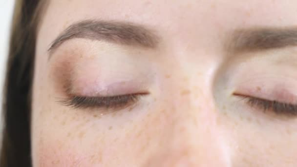 Profesjonalny makijaż artysta zastosowanie eyeshadow okiem modelu za pomocą specjalnej szczotki. Naturalny makijaż w salonie. Koncepcja mody i urody, makijaż — Wideo stockowe