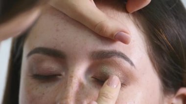 Göz makyajı yapan kadın göz farı pudrası sürüyor.