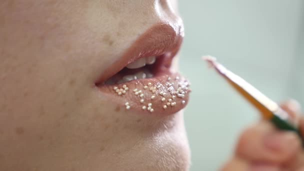 Maquillador pone confeti en los labios. confeti en los labios, maquillaje hermoso y colorante brillante de labios — Vídeo de stock