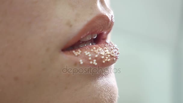 Make-up artiest zet confetti op de lippen. confetti op de lippen, mooie make-up en lichte colorer van lippen — Stockvideo