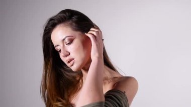 Seksi kadın moda Güzellik Portresi yavaş hareket için poz çıplak omuz boğucu ve gri arka plan üzerinde baştan çıkarıcı modelidir