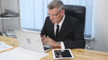 yaşlı işadamı modern ofis içinde bilgisayar ile çalışma