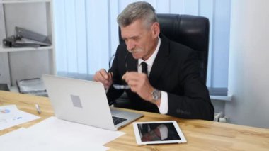 Yorgun işadamı ofisinde çalışan ilgili bir göz ile. Ağır çekimde.