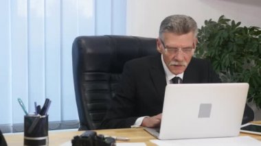 yaşlı işadamı modern ofis içinde bilgisayar ile çalışma