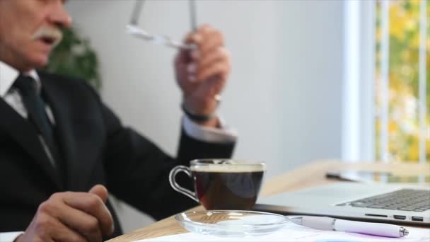 Уставший бизнесмен заканчивает работать в офисе и пить кофе. селективный фокус — стоковое видео