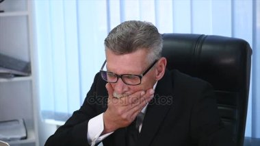 yorgun eski işadamı modern ofisindeki bir bilgisayarla çalışma