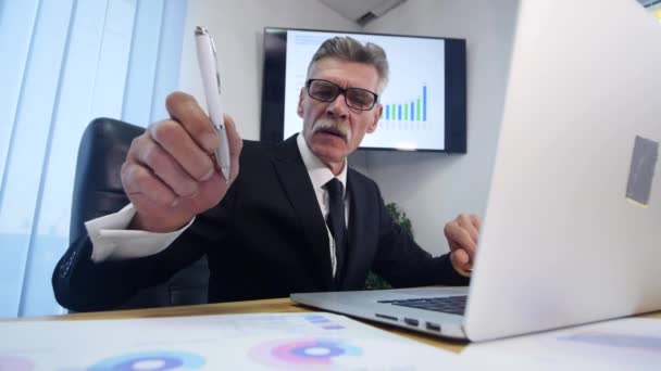 Mãos de homem de negócios digitando no computador portátil na mesa de madeira e fazer algumas notas — Vídeo de Stock