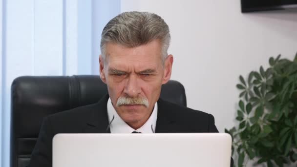 Hombre de negocios de edad avanzada que trabaja con la computadora en la oficina moderna — Vídeos de Stock