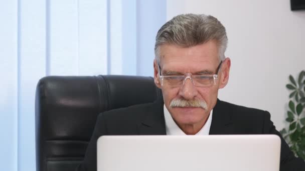 Anziano uomo d'affari che lavora con il computer in ufficio moderno — Video Stock
