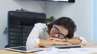 yorgun işkadını masanın üzerinde uyuyor