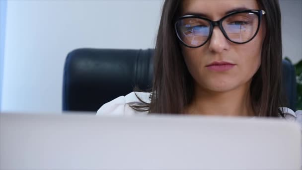 Бізнес-леді в офісі з ноутбуком — стокове відео