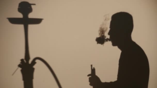 Тень человека, который курит кальян — стоковое видео
