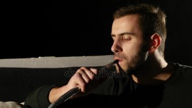 bir nargile portre siyah arka plan üzerine genç sakallı adam dumanlar