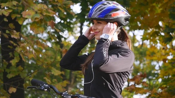 Nahaufnahme einer jungen Frau auf einem Fahrrad im Herbstpark. Zeitlupe — Stockfoto