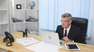 yaşlı işadamı modern ofis içinde bilgisayar ile çalışma