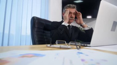 ofiste çalışmalar sırasında baş ağrısı olan işadamı