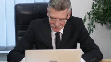 yaşlı işadamı modern ofis içinde bilgisayar ile çalışma