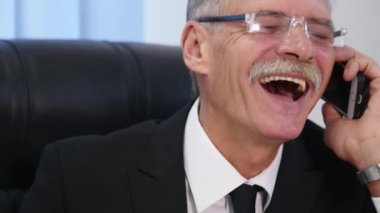 Kıdemli ofis beyaz smartphone ile konuşuyor. yakın çekim