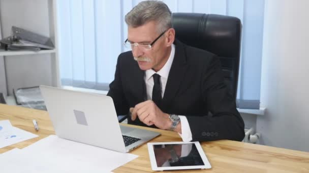 Älterer Geschäftsmann arbeitet mit Computer im modernen Büro — Stockvideo