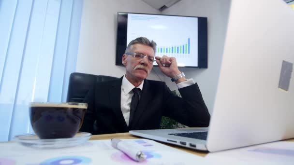 Businessman beve caffè mentre guarda lo schermo del computer portatile — Video Stock