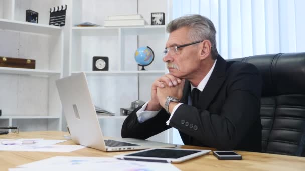 Hombre de negocios de edad avanzada que trabaja con la computadora en la oficina moderna — Vídeo de stock