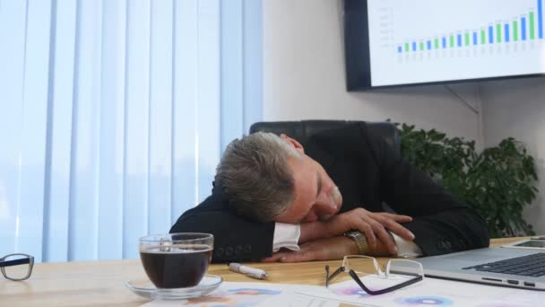 Tired businessman with laptop falling asleep in office — Stock Video