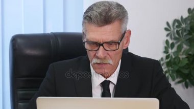 yaşlı işadamı modern ofis içinde bilgisayar ile çalışma