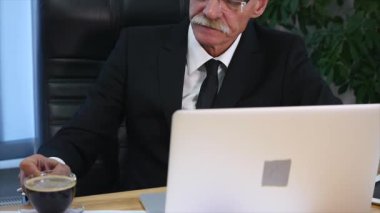 Dizüstü bilgisayar ekranı izlerken işadamı içecekler kahve