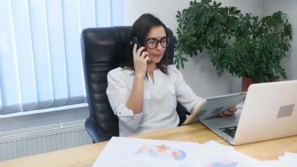Güzel, başarılı bir kadın modern ofisindeki telefonda konuşuyor — Stok video