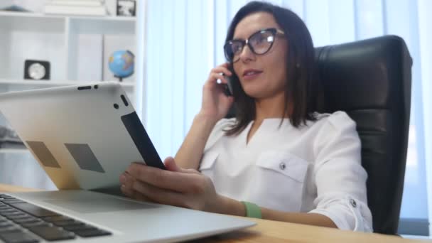 Una hermosa mujer de éxito hablando por teléfono en la oficina moderna — Vídeos de Stock