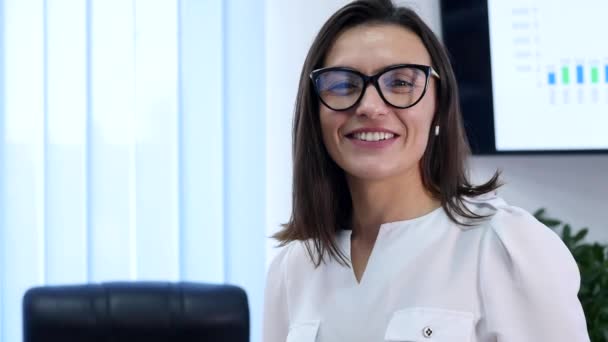 Vertrouwen volwassen zakenvrouw permanent in office. Vrouwelijke manager in kantoor camera kijken en glimlachen — Stockvideo