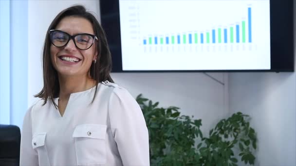 Vertrouwen volwassen zakenvrouw permanent in office. Vrouwelijke manager in kantoor camera kijken en lachend. Slow motion — Stockvideo