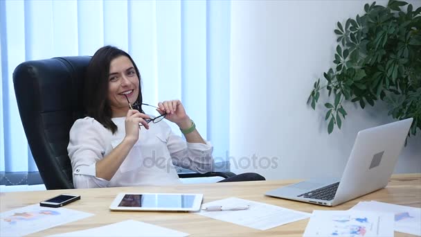 Atrakcyjna kobieta myślenia, siedząc w fotelu w biurze zwolnionym tempie — Wideo stockowe