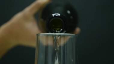 Şampanya kabarcıklar ile bir cam içine siyah arka plan üzerine dökülür.