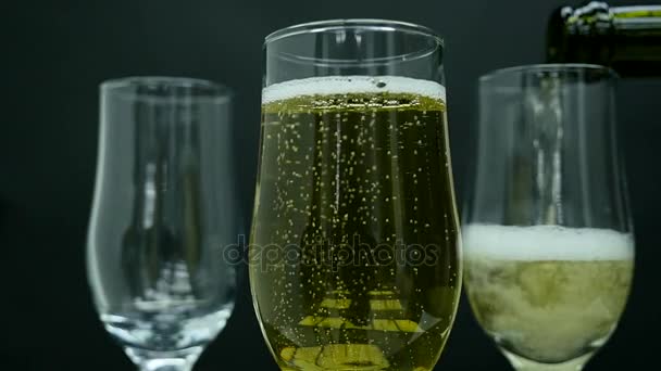 Champagne avec bulles versé dans un verre sur fond noir — Video