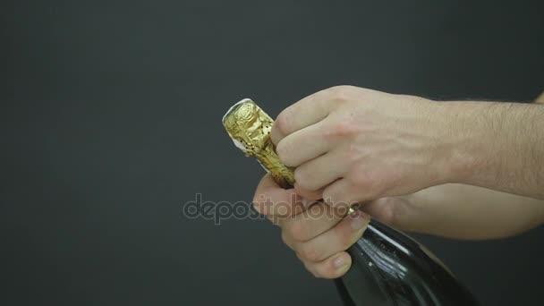 シャンパンの爆発。シャンパン ボトルのクローズ アップを開き男の手。休日点滅背景のボケ味のスパーク リング ワイン。シャンパン ボトルのクローズ アップ。成功を祝っています。スローモーション — ストック動画
