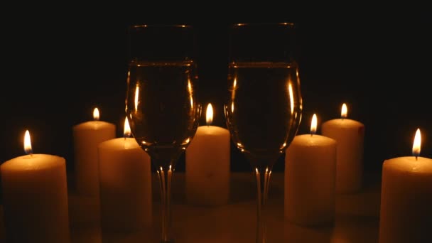 Dvě sklenice šampaňského se svíčkami na černém pozadí — Stock video