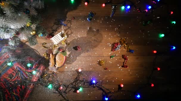 Vista superior. Mesa marrón de madera decorada con cosas navideñas y guirnaldas. Luces rojas de Navidad. De cerca. — Vídeos de Stock