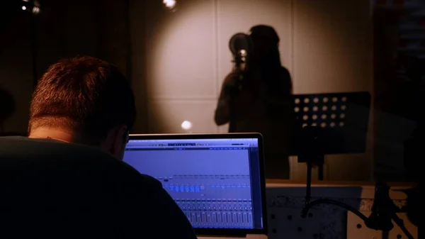Mulher é gravada no estúdio de gravação com um engenheiro de som — Fotografia de Stock