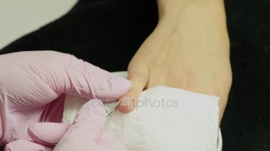 Closeup çekim tarafından bir güzellik tırnak törpüsü ile manikür alma bir tırnak salonu içinde bir kadın. Kadın Başlarken tırnak manikür. Şevval Özçelik Güzellik dosya bir müşteriye çivi