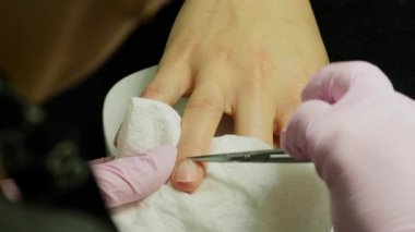 Closeup çekim tarafından bir güzellik tırnak törpüsü ile manikür alma bir tırnak salonu içinde bir kadın. Kadın Başlarken tırnak manikür. Şevval Özçelik Güzellik dosya bir müşteriye çivi