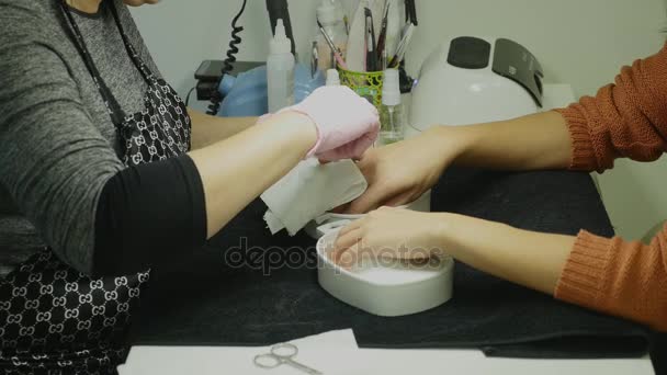 Detailní záběr ženy v nehtový salon příjem manikúru od kadeřnice s pilník. Žena stále nehty manikúra. Kosmetička soubor hřebíky k zákazníkovi — Stock video