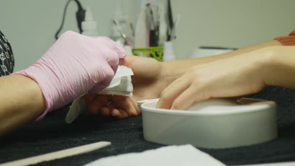 Closeup shot of a woman in a nail salon receiving a manicure by a beautician with nail file. Woman getting nail manicure. Beautician file nails to a customer — Stock Video