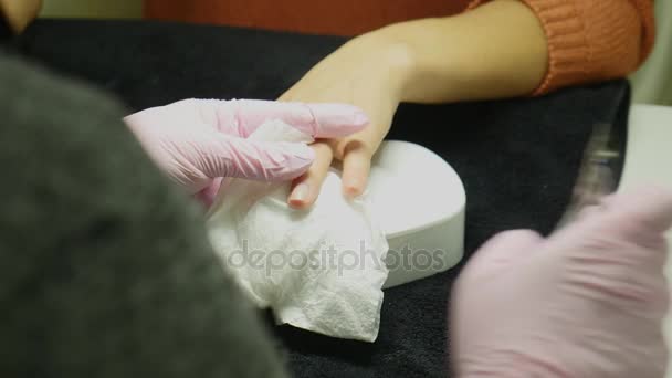 Närbild skott av en kvinna i en nagelsalong som tar emot en manikyr av en kosmetolog med nagelfil. Kvinna får spik manikyr. Kosmetolog filen naglar till en kund — Stockvideo