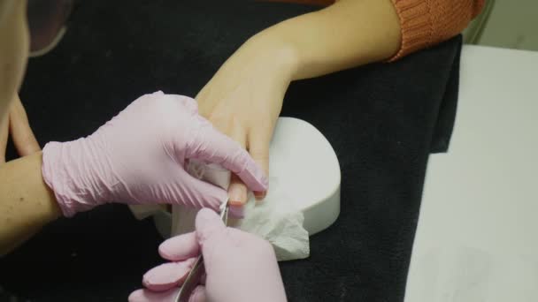 Close-up shot van een vrouw in een nagel salon een manicure door een schoonheidsspecialiste met nagelvijl ontvangen. Vrouw krijgen nagel manicure. Schoonheidsspecialiste bestand nagels aan een klant — Stockvideo