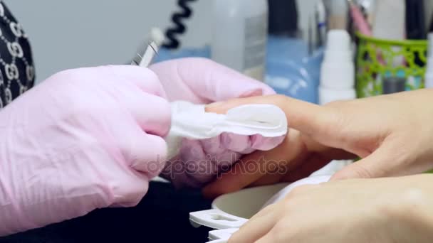 一个女人在接收由美容师与指甲锉指甲美甲沙龙的特写镜头。女人得到的指甲修指甲。美容师文件钉给客户 — 图库视频影像