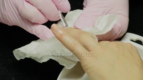 Nahaufnahme einer Frau in einem Nagelstudio, die von einer Kosmetikerin mit Nagelfeile eine Maniküre erhält. Frau bekommt Nagelmaniküre. Kosmetikerin feilt Nägel an Kundin — Stockvideo
