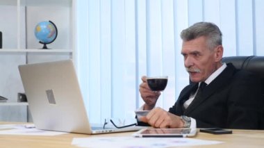 Dizüstü bilgisayar ekranı izlerken işadamı içecekler kahve