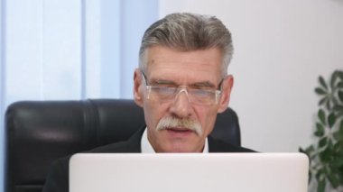 yaşlı işadamı modern ofis içinde bilgisayar ile çalışma